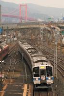 若戸大橋をバックに走る415系