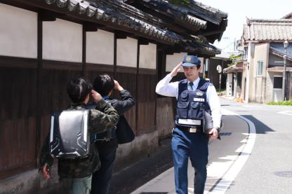警察官が子供に対し敬礼をする様子